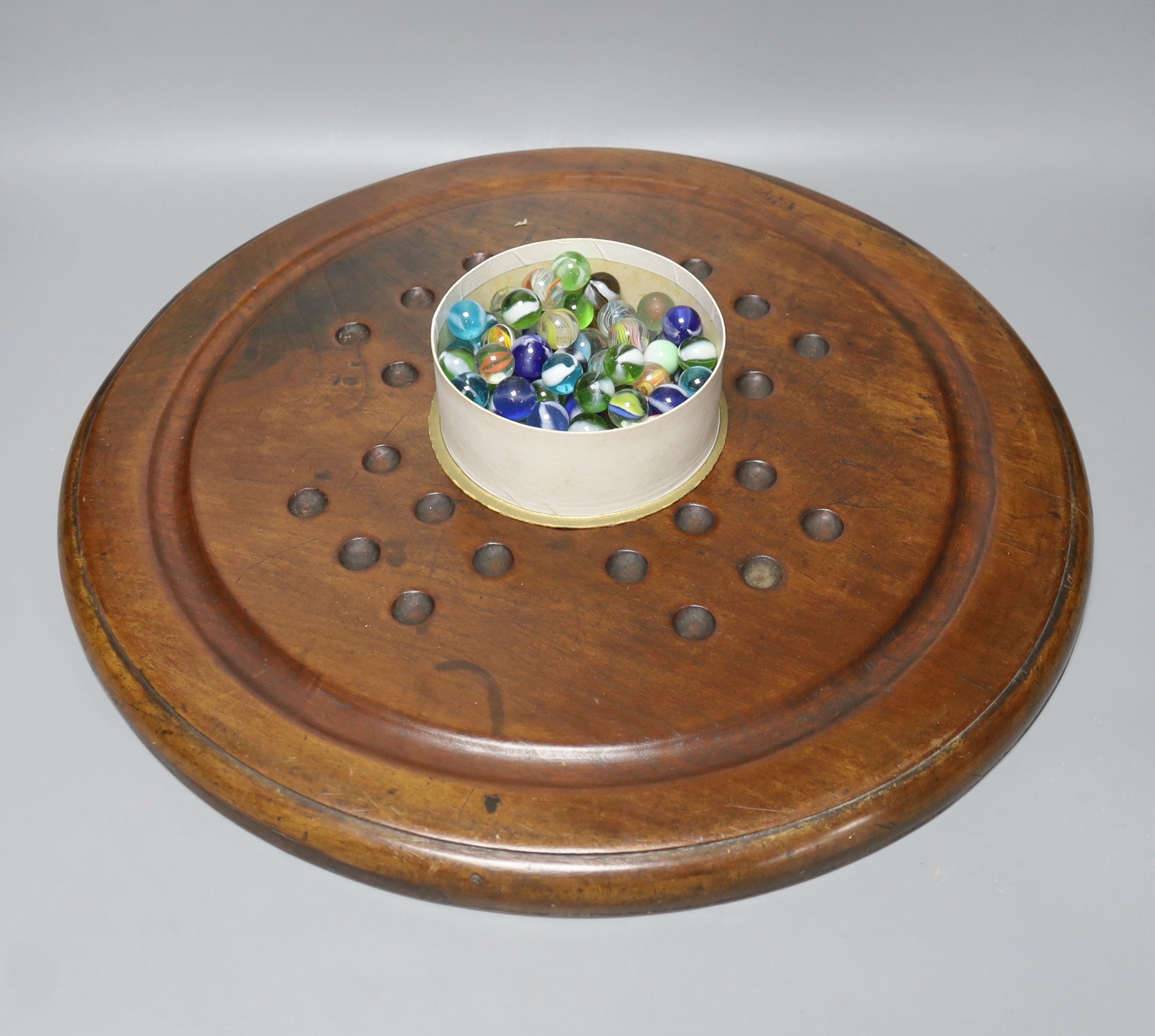 A collection of glass marbles and a mahogany solitaire board 45cm